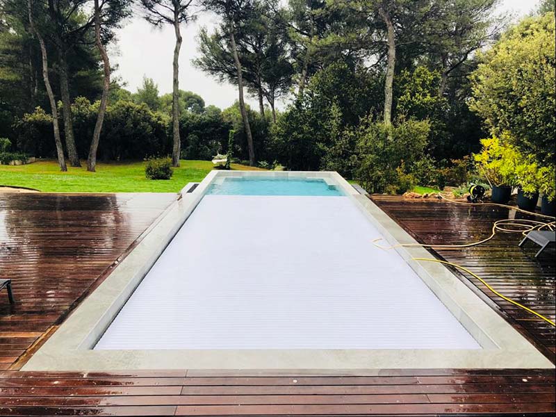 Photographie d'une couverture automatique de piscine. Planète Eau Piscines, Construction, Rénovation, Entretien. Artisan pisciniste sur Aix en Provence et ses alentours.