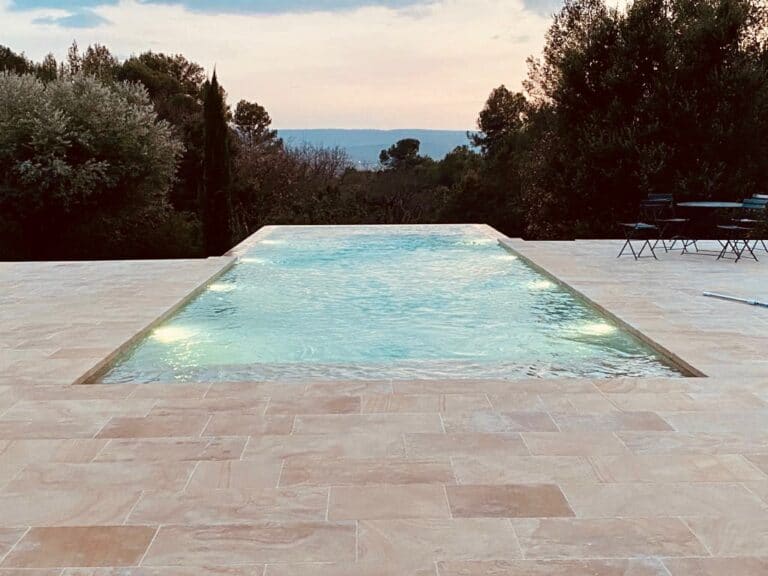 Piscine débordante avec terrasse et vue et coucher de soleil